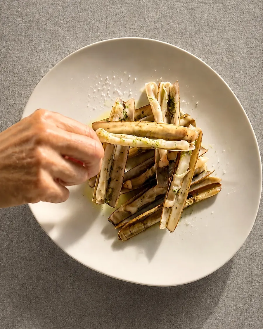 Razor clams served on a white plate